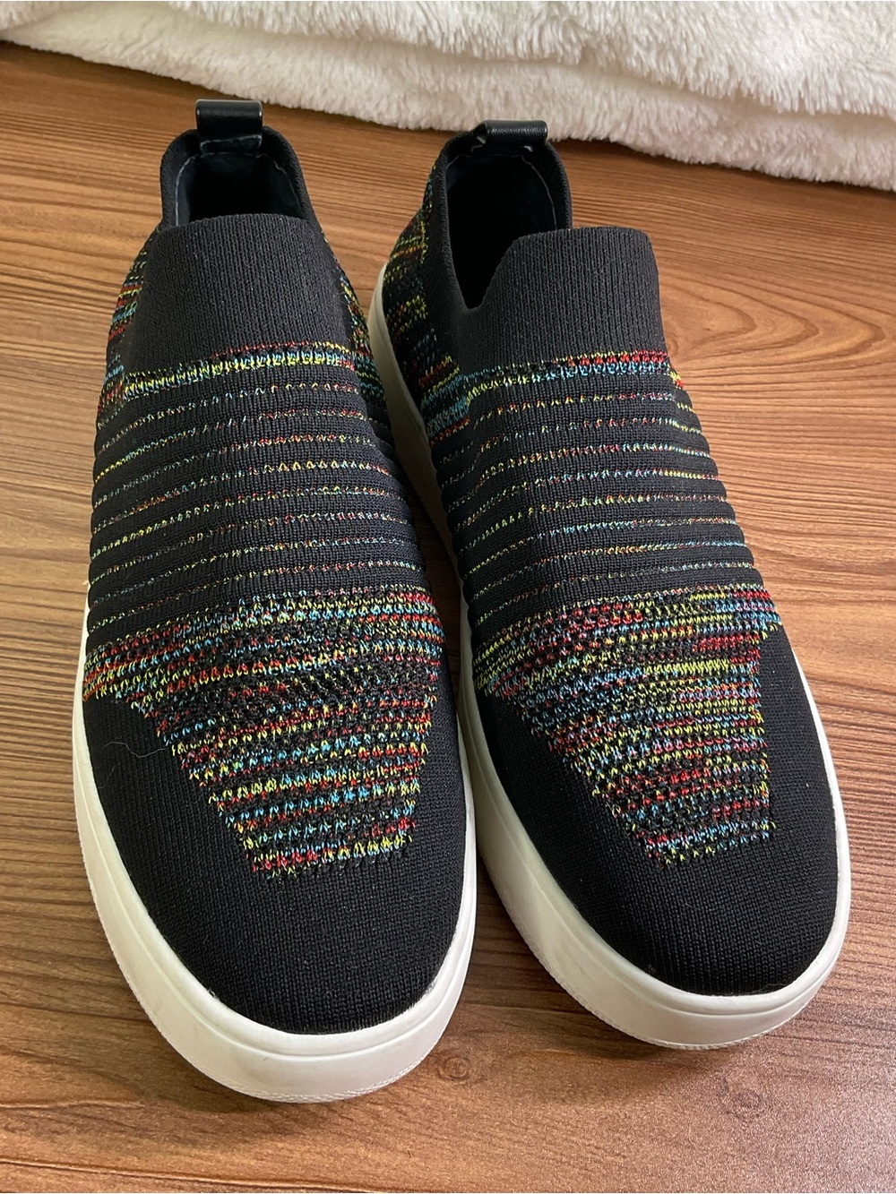 Black and multi-coloured Steve Madden women’s knit slip on sneakers.